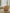 Beige armchair in a room with large windows and white curtains