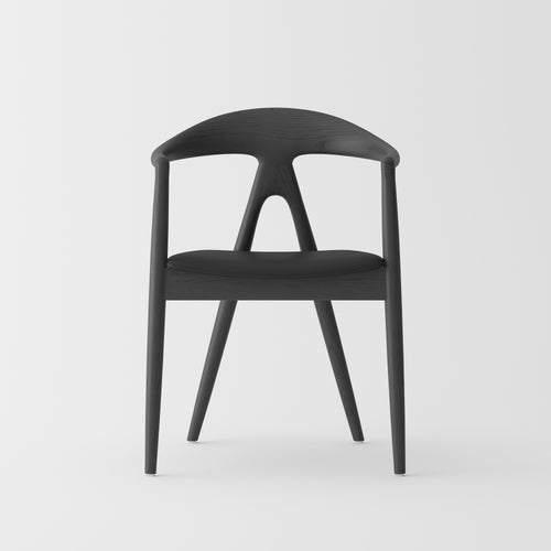 A modern black molded plastic dining chair with a curved backrest and tapered legs, shown from the front on a light gray background.