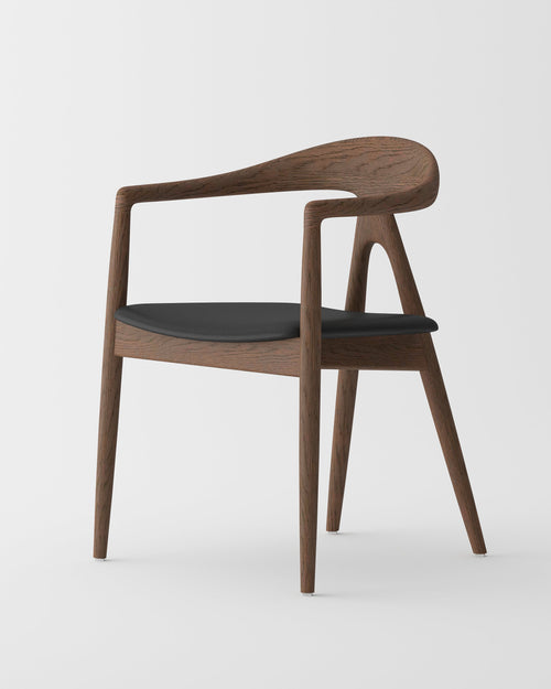 A modern wooden armchair with a curved backrest, integrated armrests, and a black upholstered seat cushion, shown on a light gray studio background.