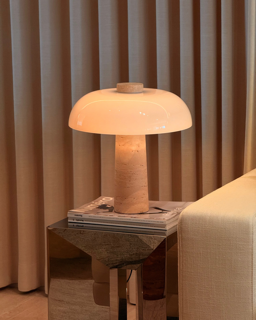 Table lamp on a side table with curtains in the background