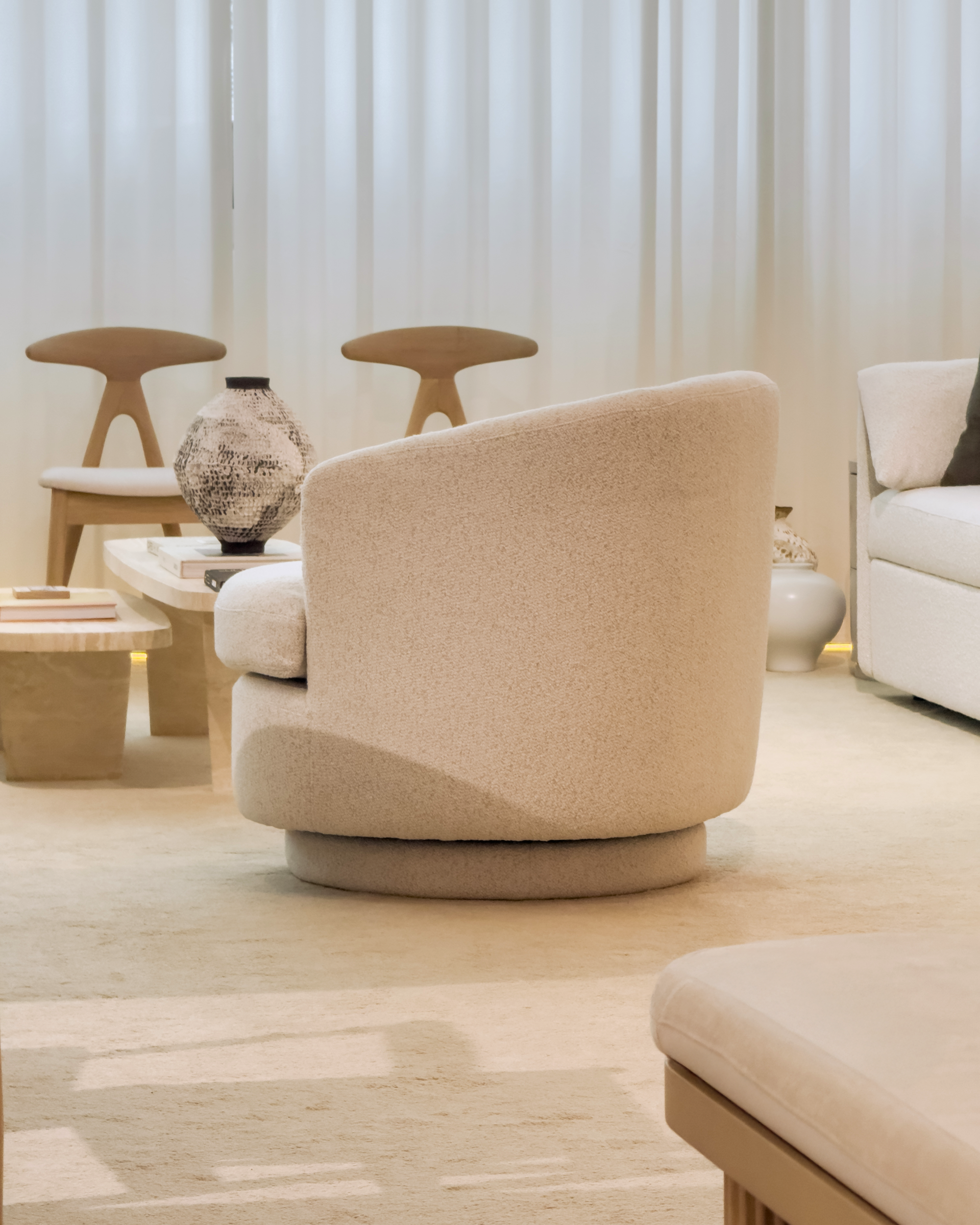 Beige armchair in a modern living room setting with neutral decor.