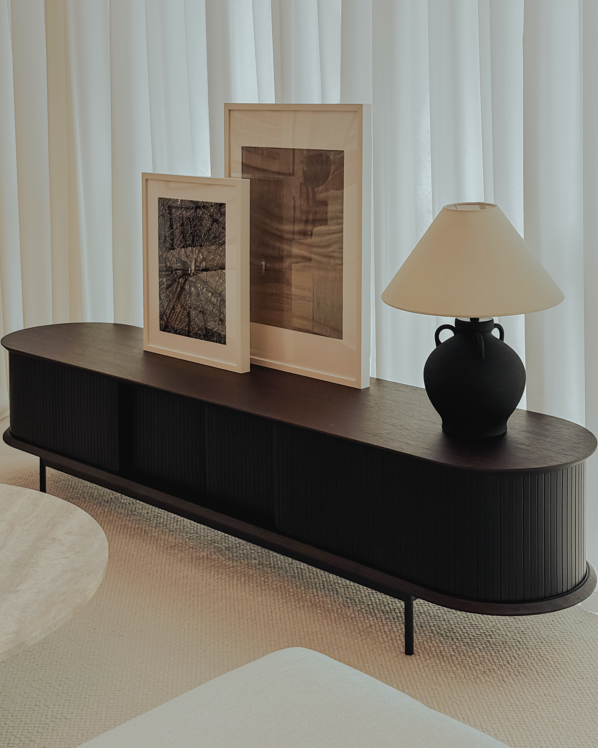 Modern dark wood console table with decorative items against a neutral background