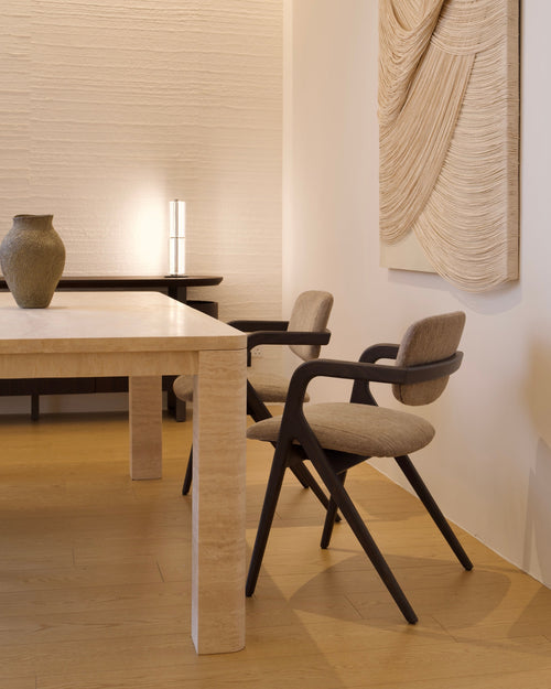 Modern dining room with a table and chairs in a minimalistic setting.