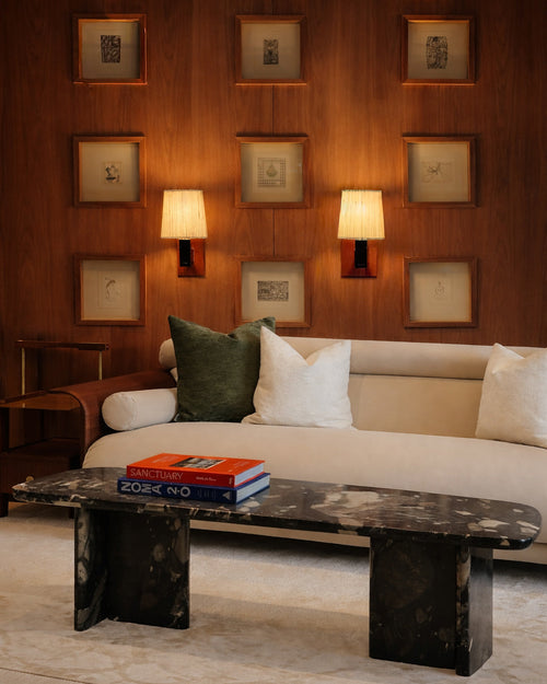 Modern living room with a sofa, coffee table, and wall art.