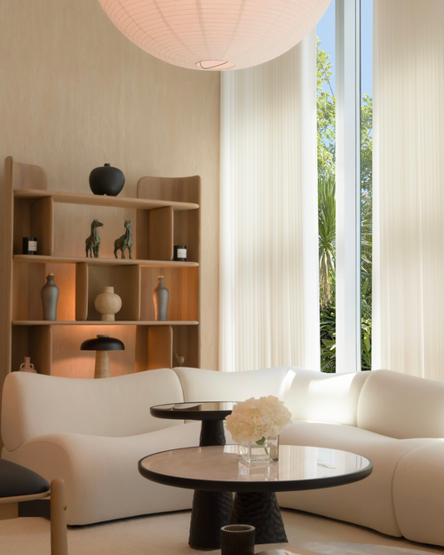 Modern living room with a bookshelf, sofa, and large window.