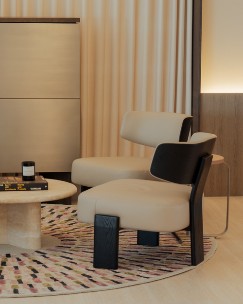 Modern chair with black legs in a stylish room with striped curtains and a rug.