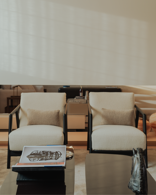 Two white chairs with beige cushions in a modern interior setting.