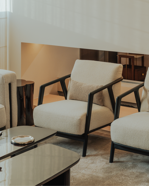Modern living room with beige armchairs and a coffee table.