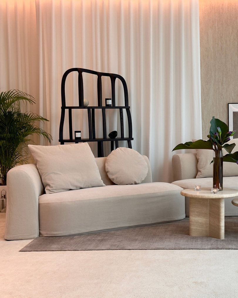 Modern living room with beige sofa, coffee table, and decorative elements.