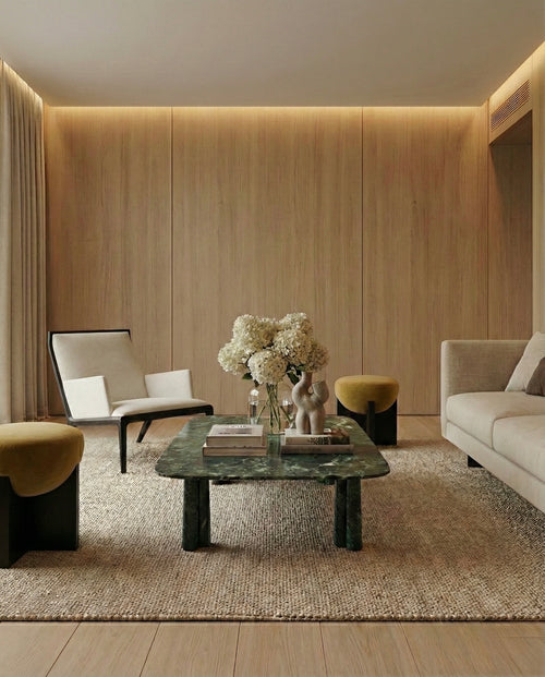 Modern living room with a marble coffee table, chairs, and a vase of flowers.