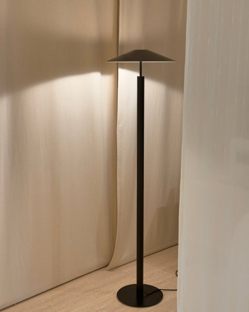 Modern black floor lamp against a neutral wall
