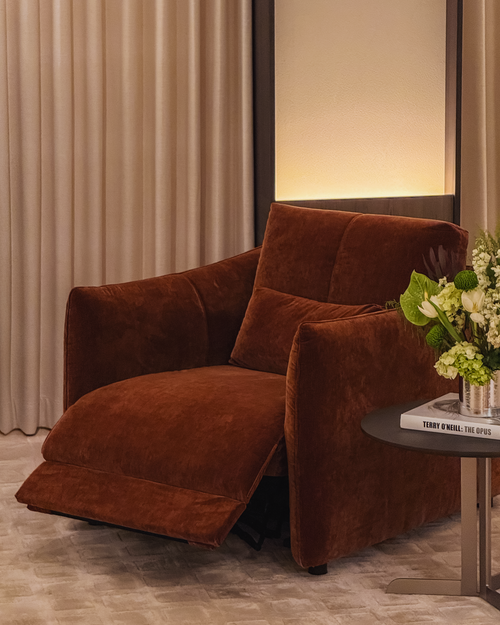 Brown armchair in a room with a table and flowers