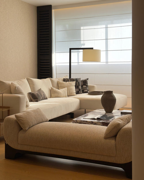 Modern living room with beige sectional sofa and decorative pillows.