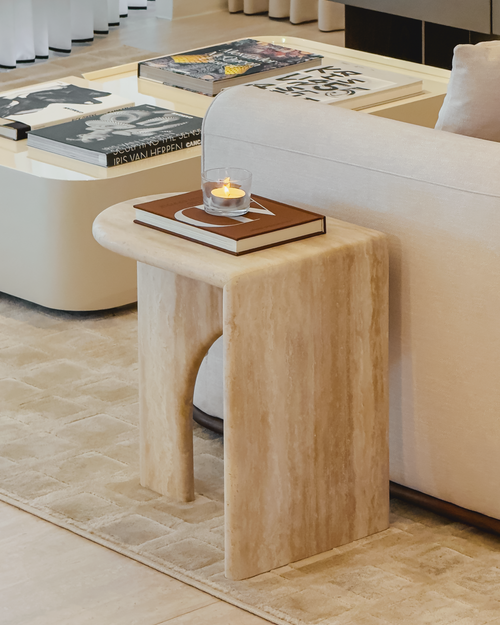 Modern living room with a wooden side table, books, and a candle.