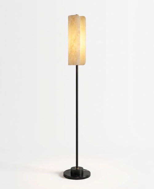 Robyn floor lamp featuring a glowing Spanish alabaster shade, slim black metal stem and natural Black Marquina marble base.