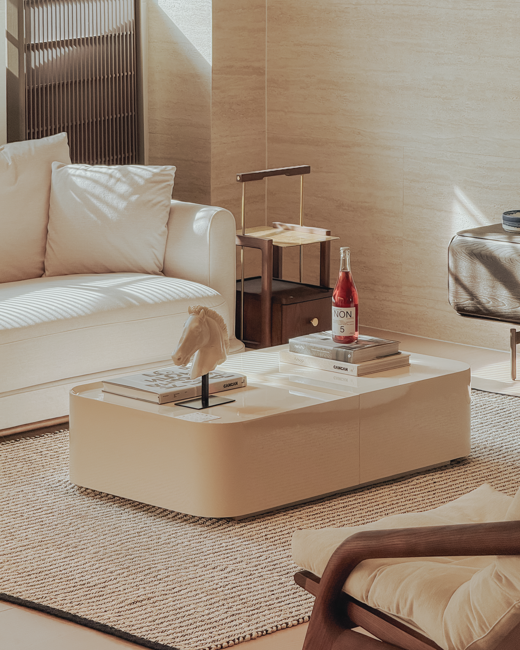 Modern living room with a beige sofa, coffee table, and armchair.