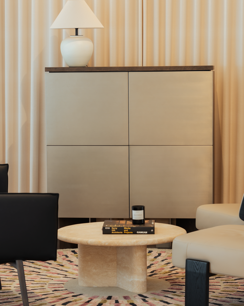Modern interior with a beige cabinet, round table, and chairs.
