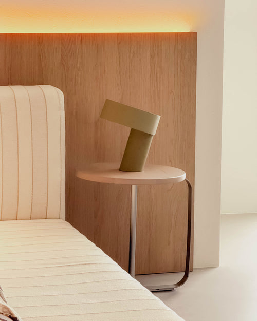 Modern bedroom with wooden headboard, bed, and side table with lamp.