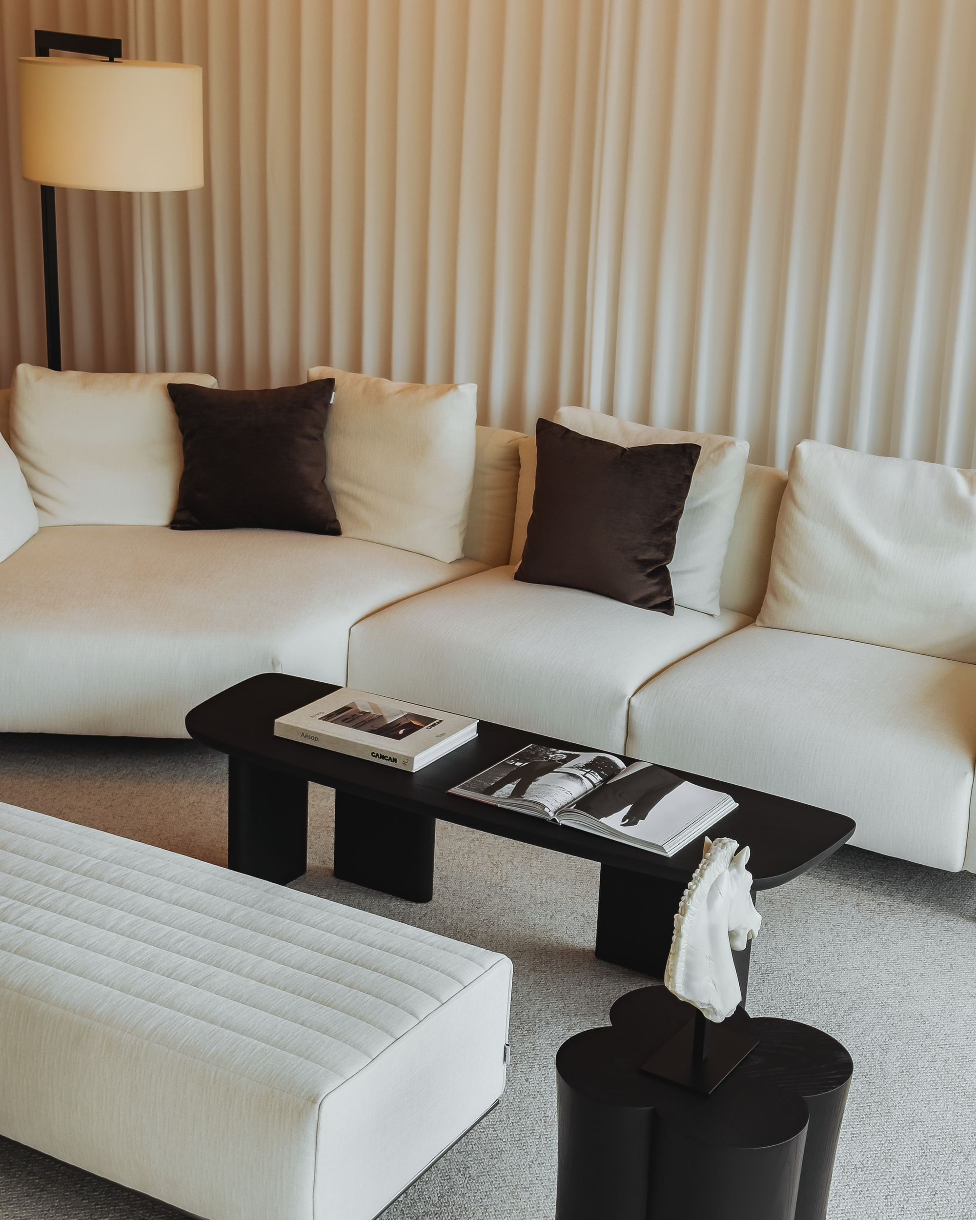 Modern living room with a white sofa, coffee table, and decorative items.