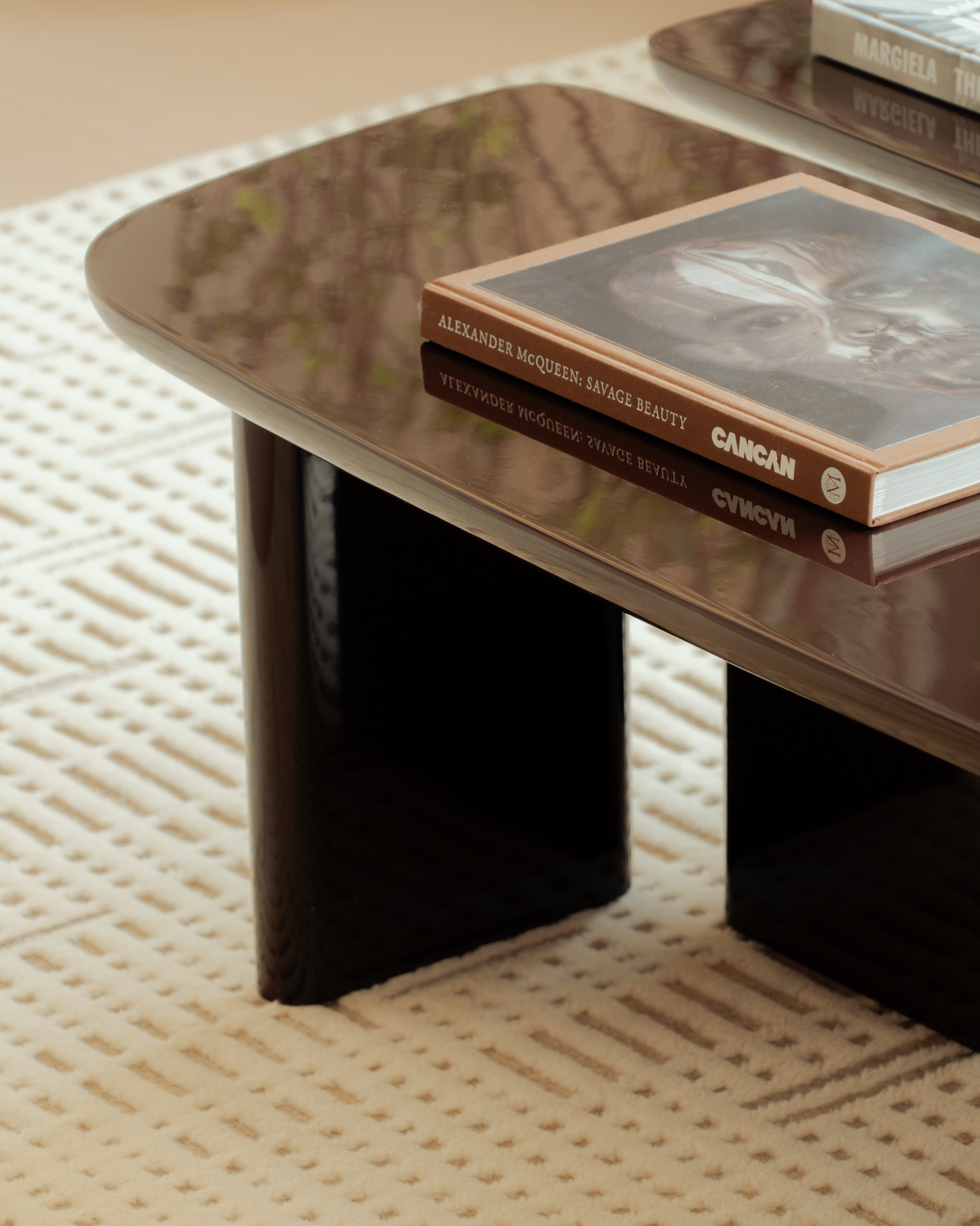 Wooden coffee table with books on a textured beige floor