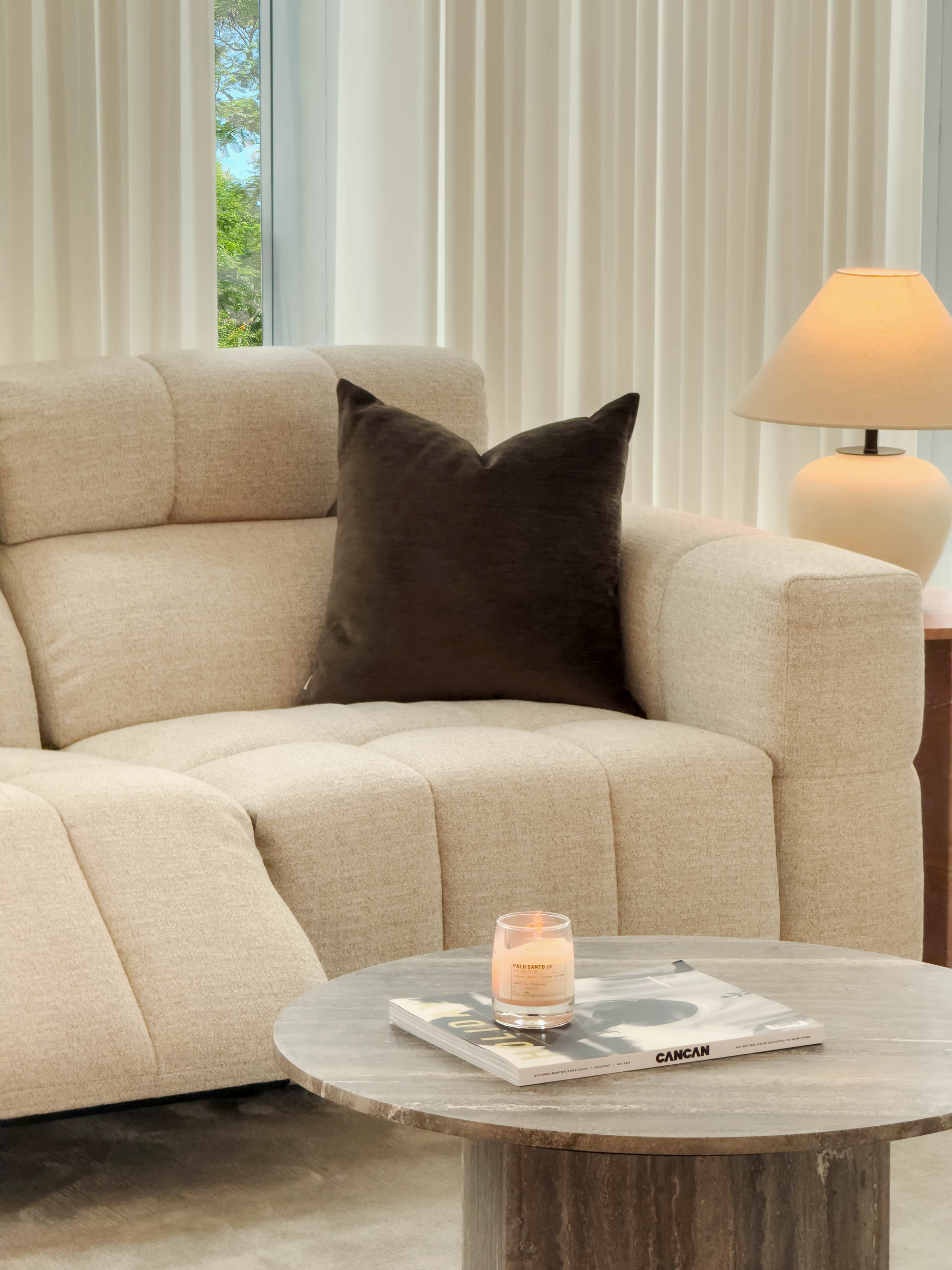 Beige sofa with a brown pillow in a living room setting
