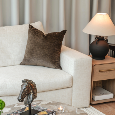 Living room with a beige sofa, marble coffee table, and decorative items.