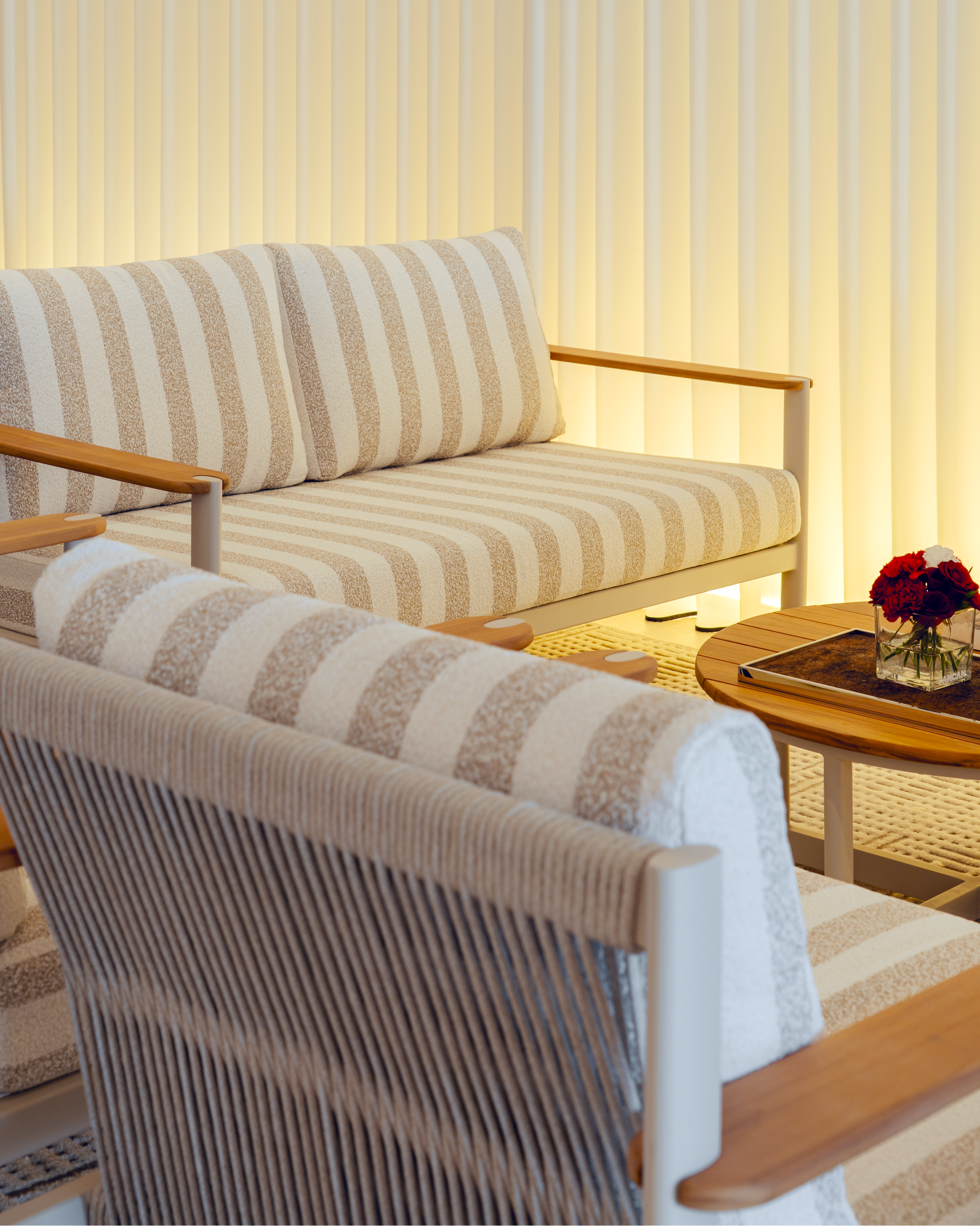 Striped outdoor furniture set with a chair and sofa against a striped wall.
