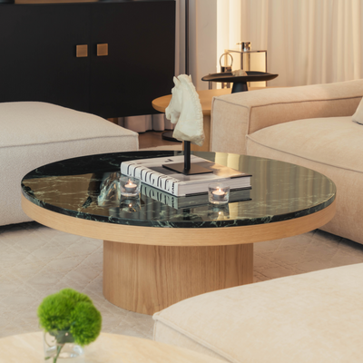 Modern living room with a round coffee table, books, and decorative items.