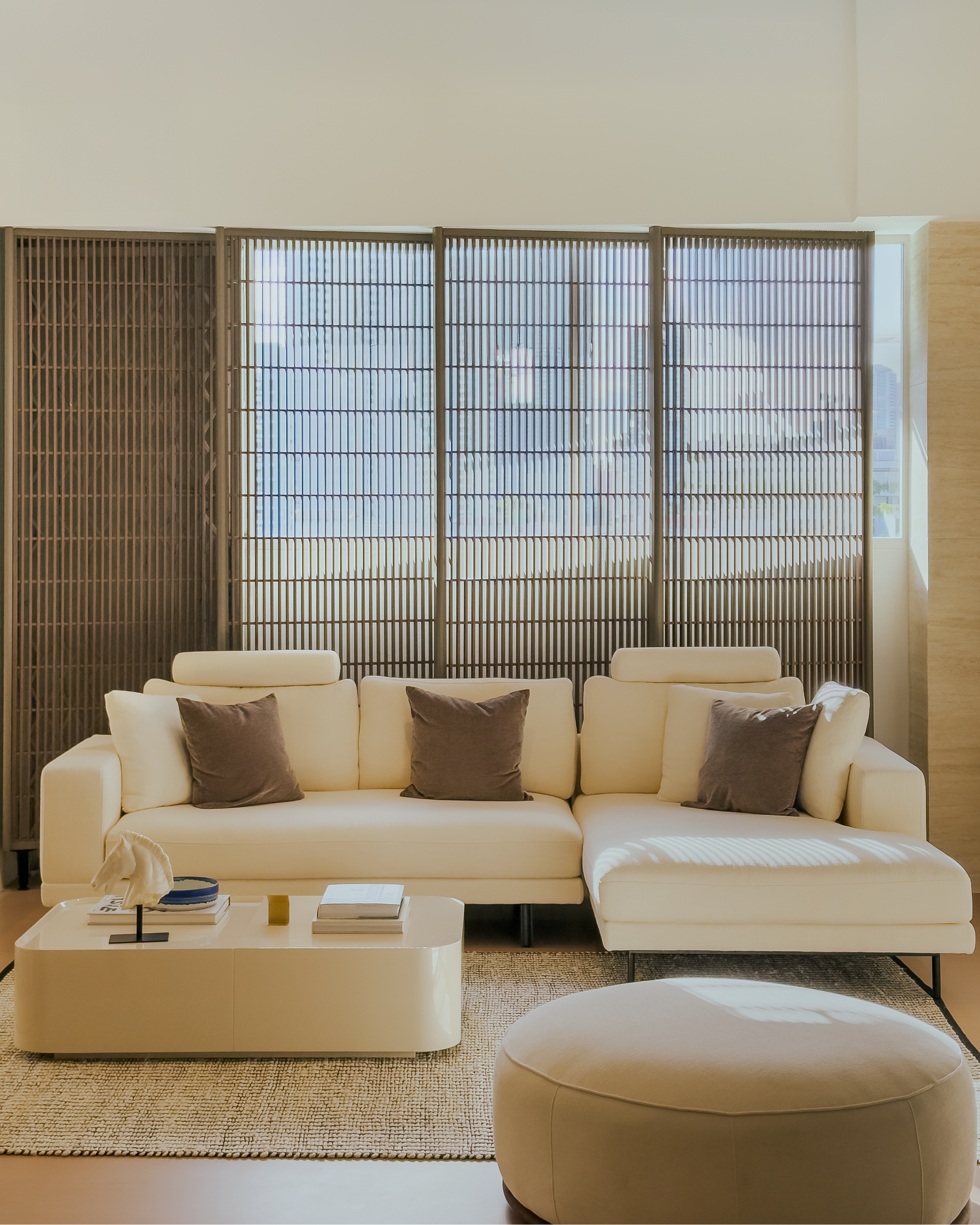 Modern living room with a beige sectional sofa, coffee table, and ottoman.