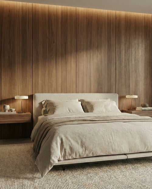Modern bedroom with a wooden headboard and neutral bedding.