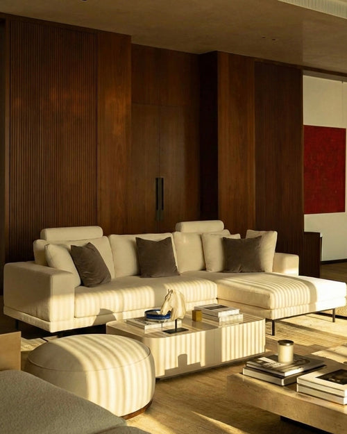 Modern living room with a beige sectional sofa, coffee table, and decorative items.