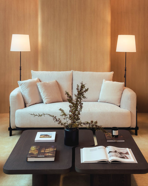 Modern living room with a beige sofa, coffee table, and decorative elements.