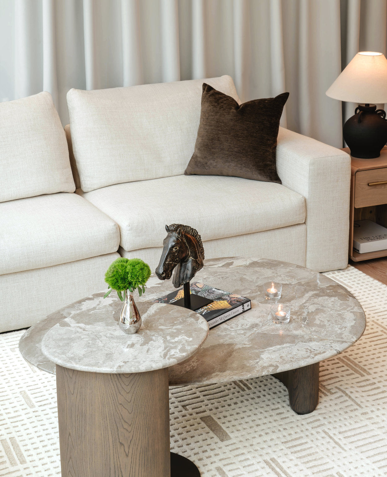 Living room with a white sofa, marble coffee table, and decorative items.
