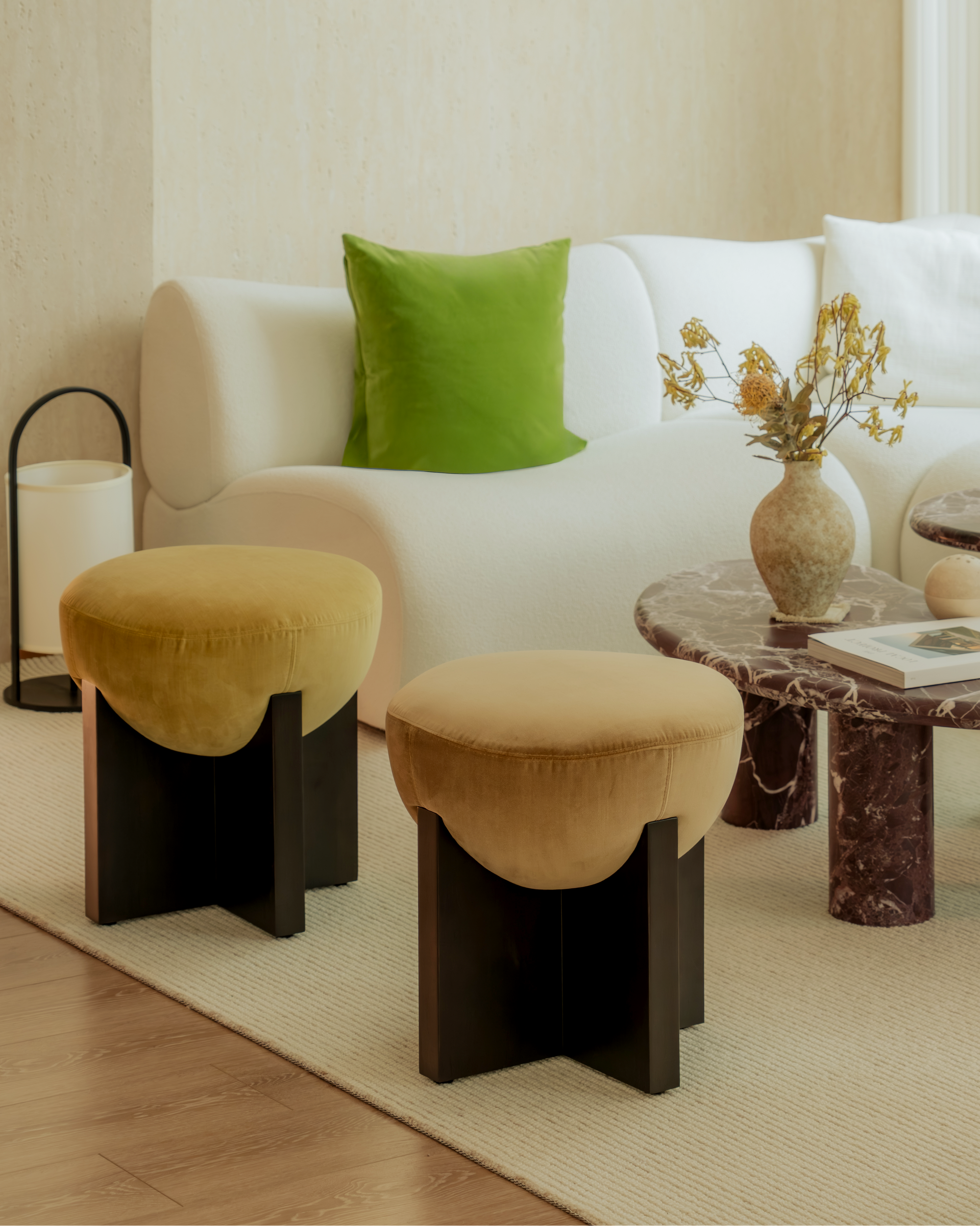 Modern living room with a white sofa, green pillow, and decorative items.