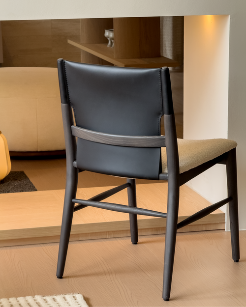 Modern chair with black backrest and wooden frame in a room setting