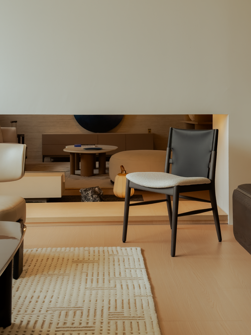 Modern interior with a chair and sofa on a beige floor.