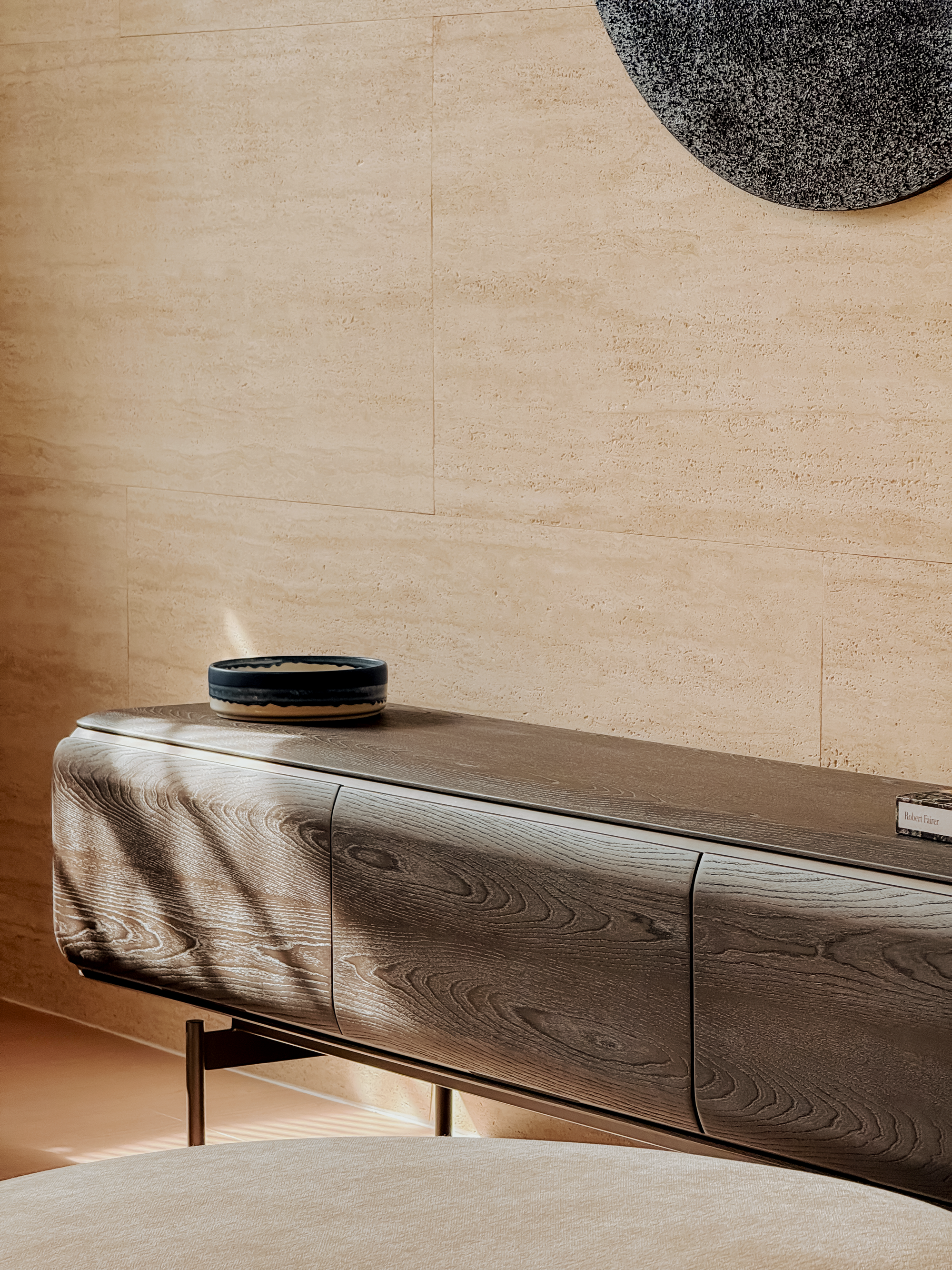 Wooden console table with decorative bowl against a beige wall