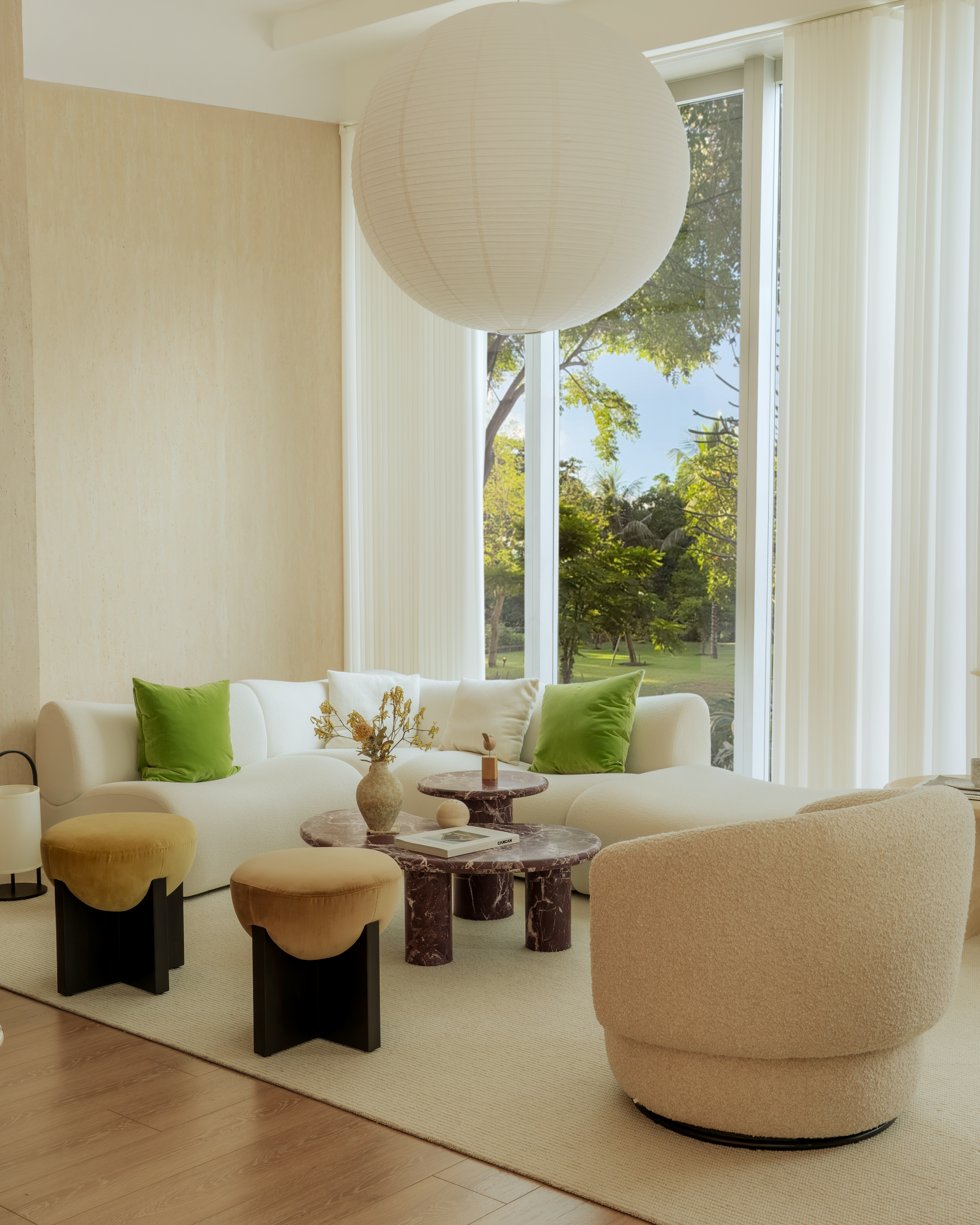Modern living room with beige sofa, green pillows, and a large window.