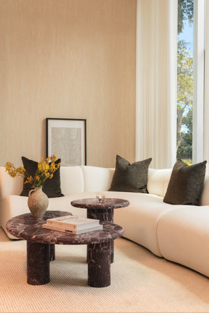 Modern living room with a beige sofa, marble coffee table, and decorative elements.