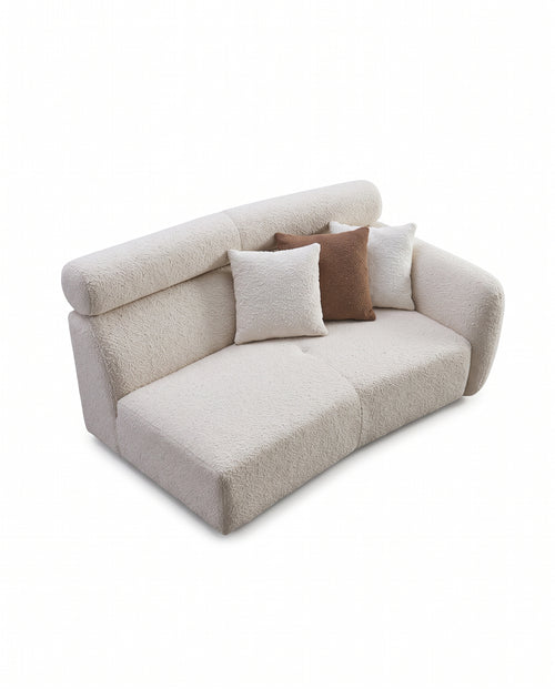 A modern curved two-seater sofa upholstered in a textured bouclé fabric, shown with three decorative throw pillows on a clean white background.