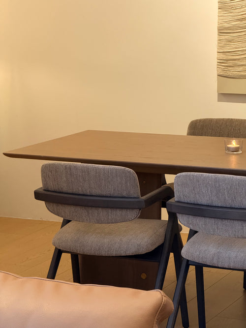 Dining table with gray chairs in a room with beige walls and flooring.