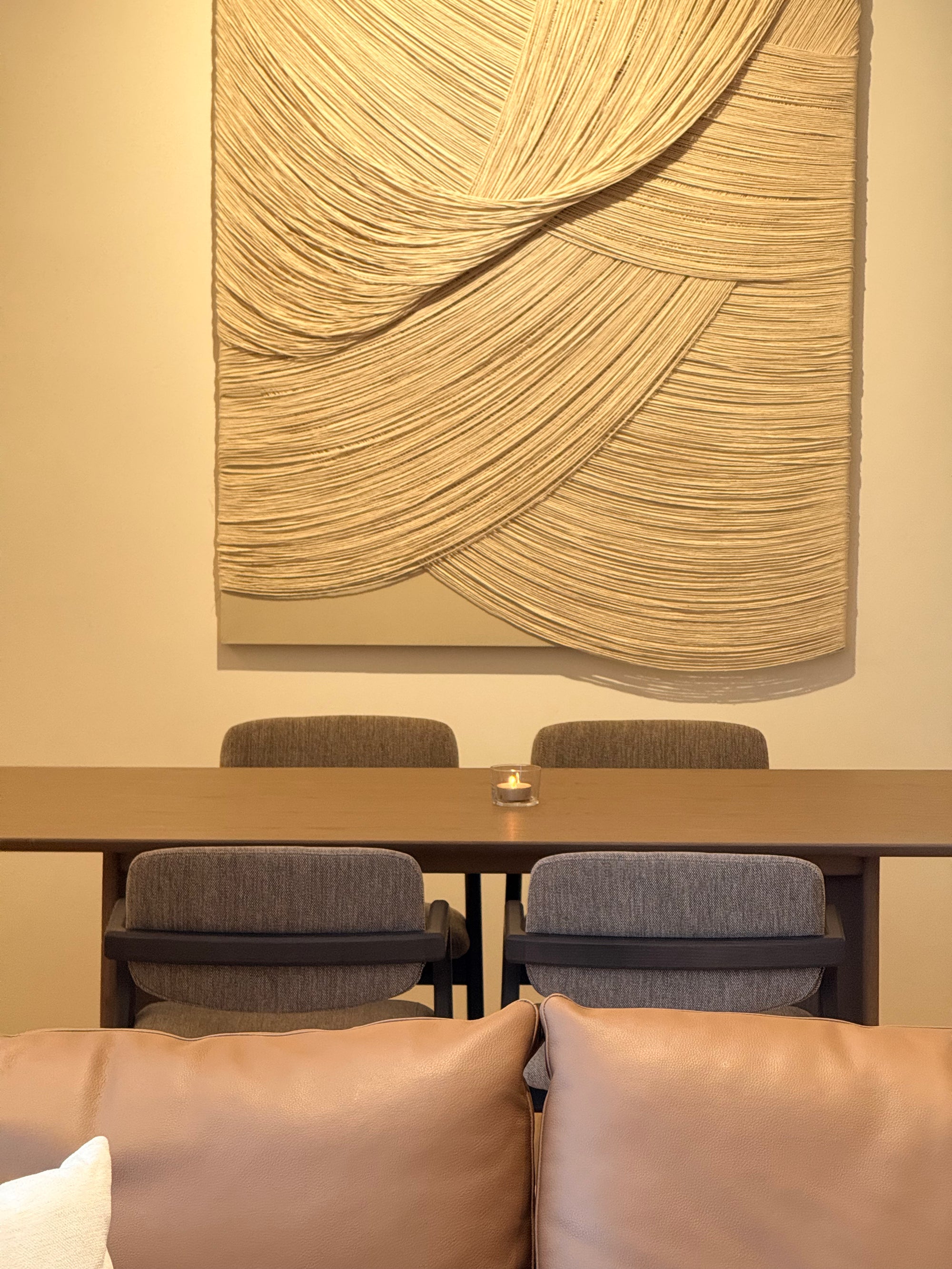 Conference room with a large abstract wall art piece, table, and chairs.