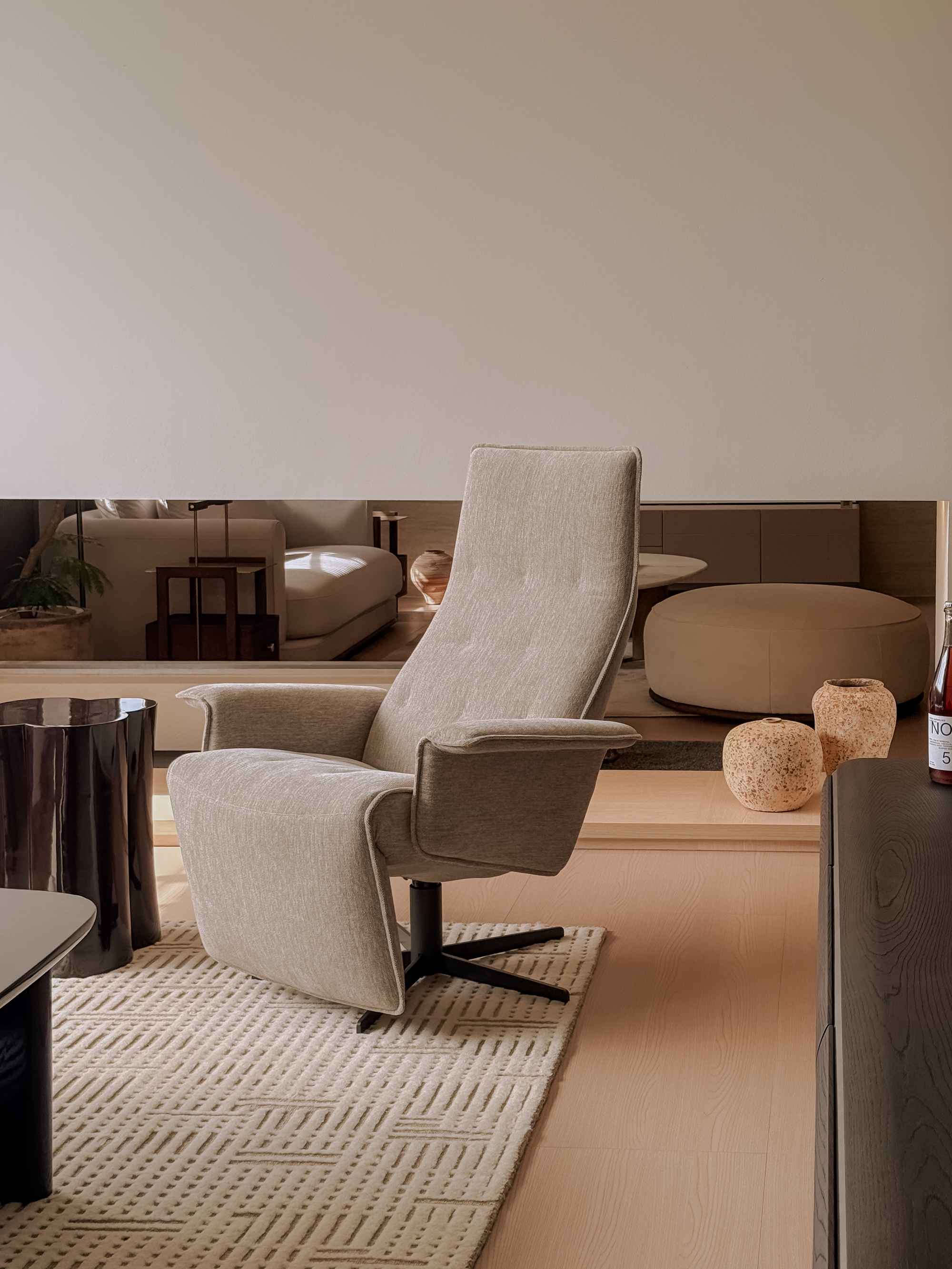 Beige armchair in a modern living room setting with neutral tones.